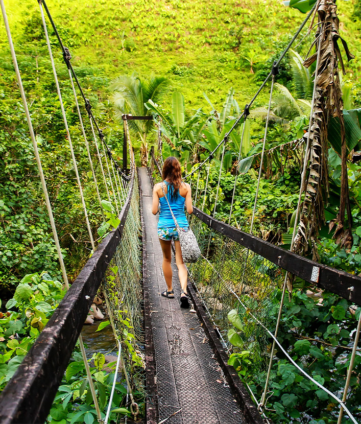 girl walking across bridge in fiji