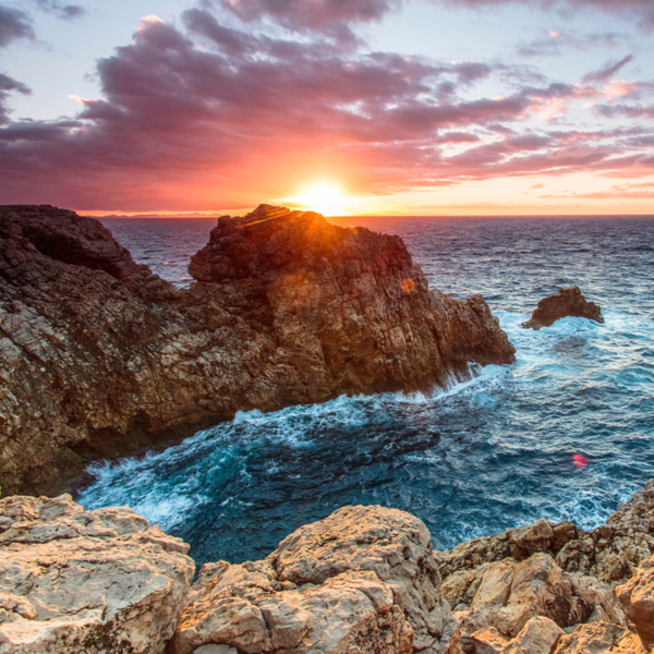 sun setting over sea at menorca beach