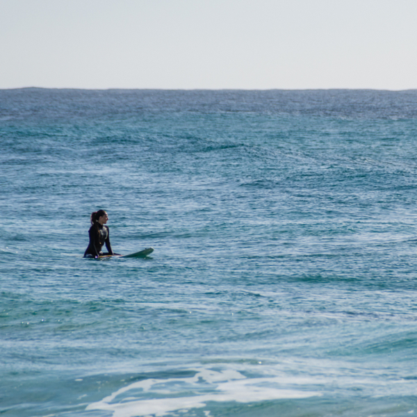 woman surfing at Cavalleria Beach in menorca