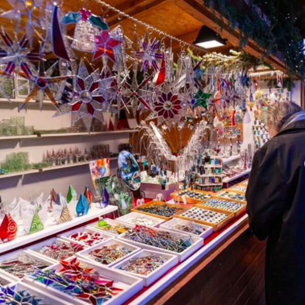 man browsing decorations at vienna christmas market