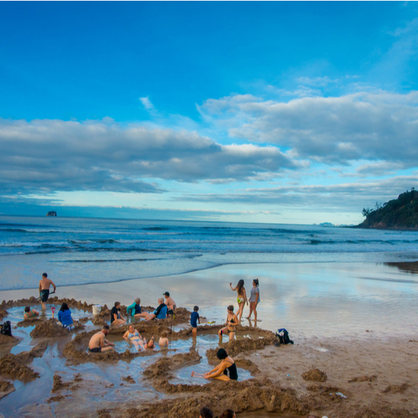 people digging personal hot springs at Hot Water Beach in Auckland