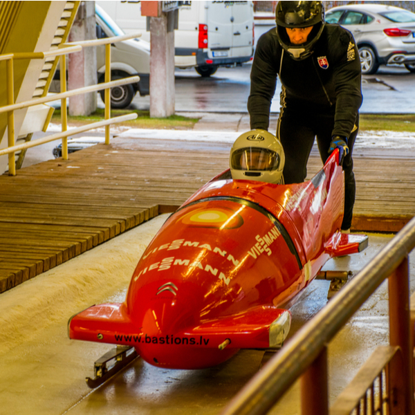 person riding a bobsled solo on riga track