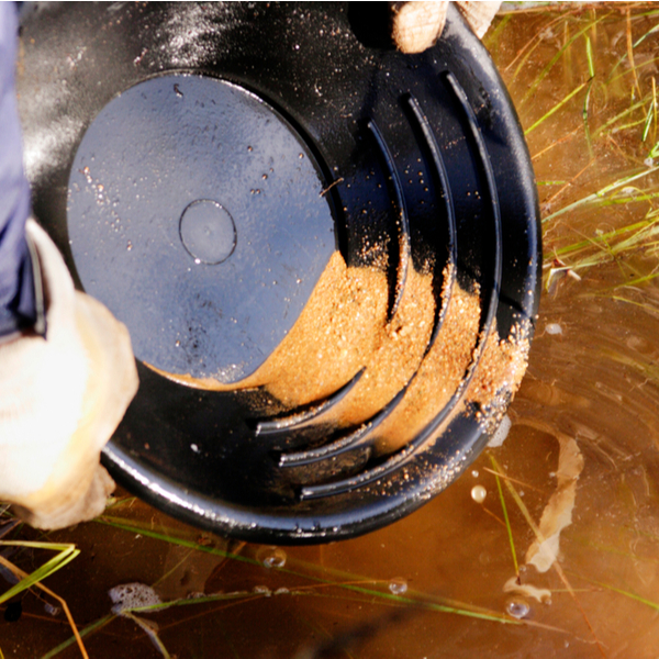 person gold panning in lapland river