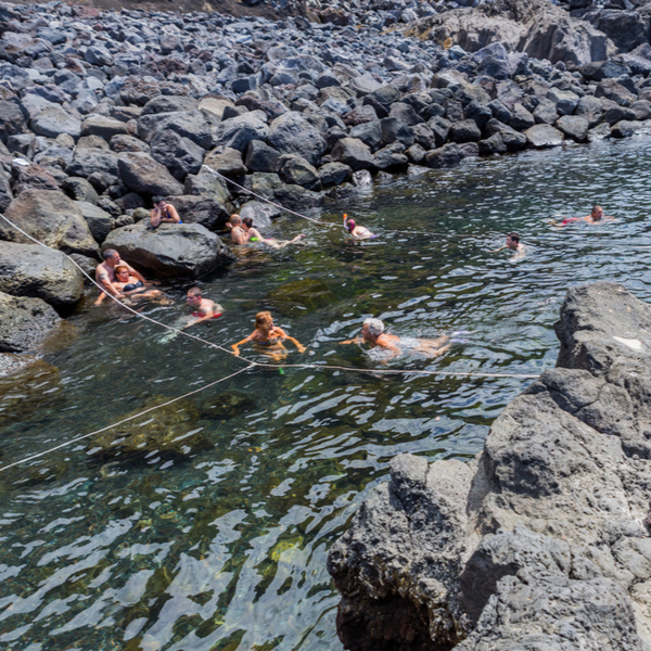 people swimming in the thermal pool at Ferraria in the azores