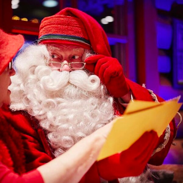 santa claus reading letters at his post office in lapland