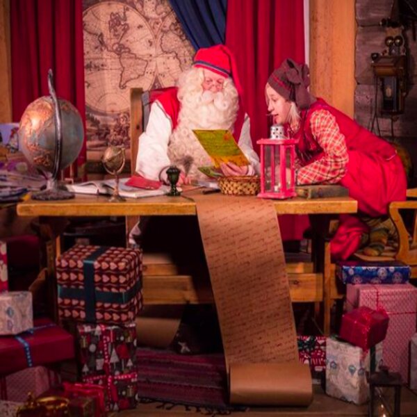 child talking to santa at his office in lapland