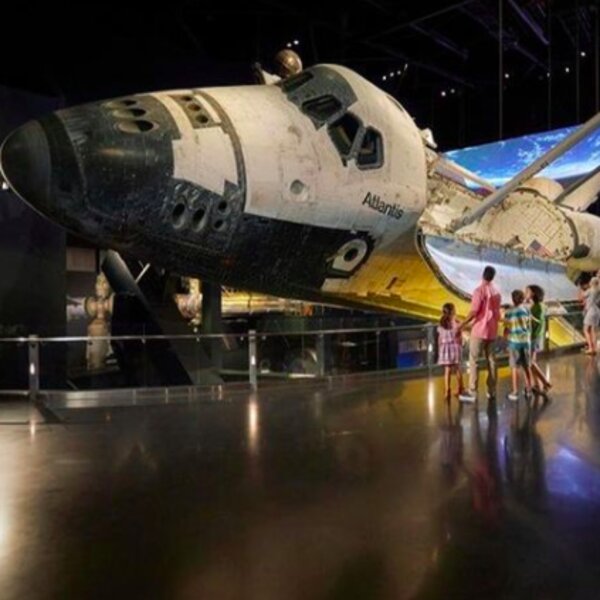 people looking at a plane exhibit at the space center in orlando
