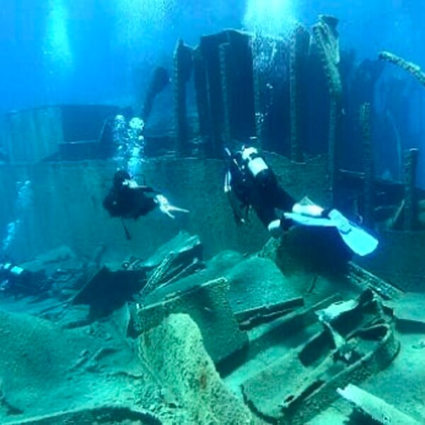 divers exploring a shipwreck on crete beach