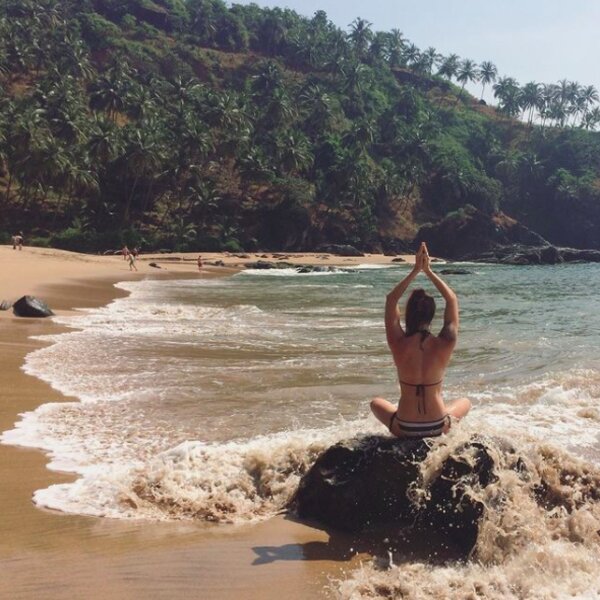 woman doing yoga on a beach in goa