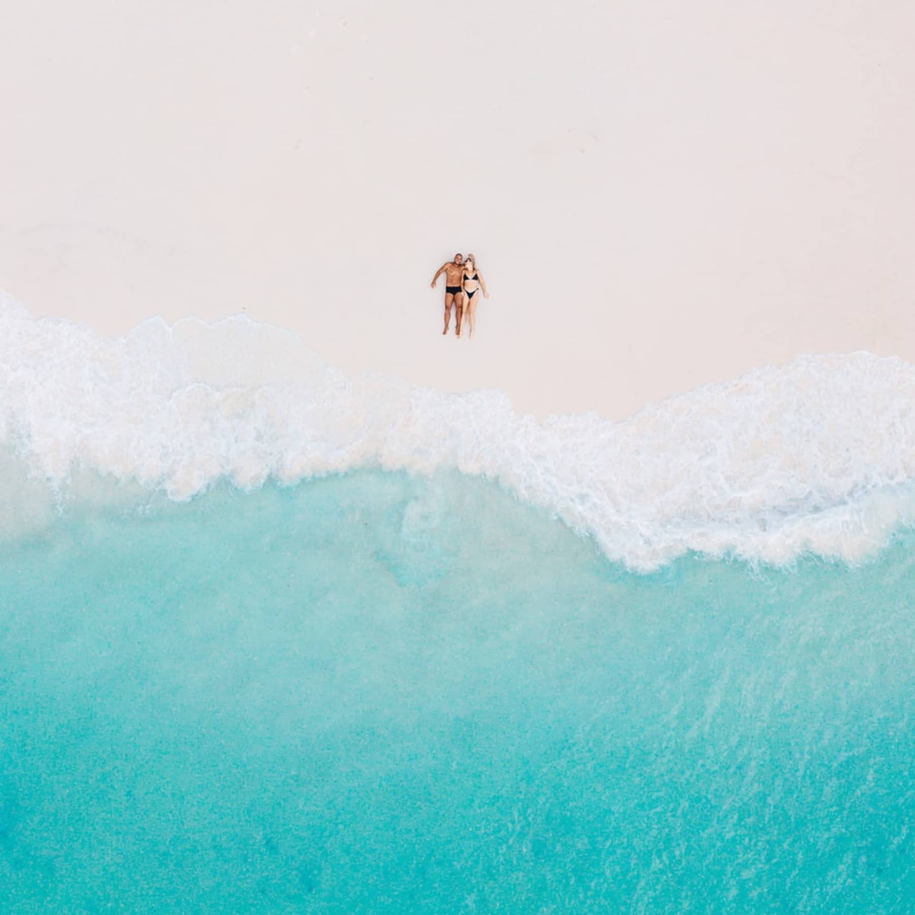 Couple relaxing on a an empty beach in the Seychelles - seychelles honeymoon