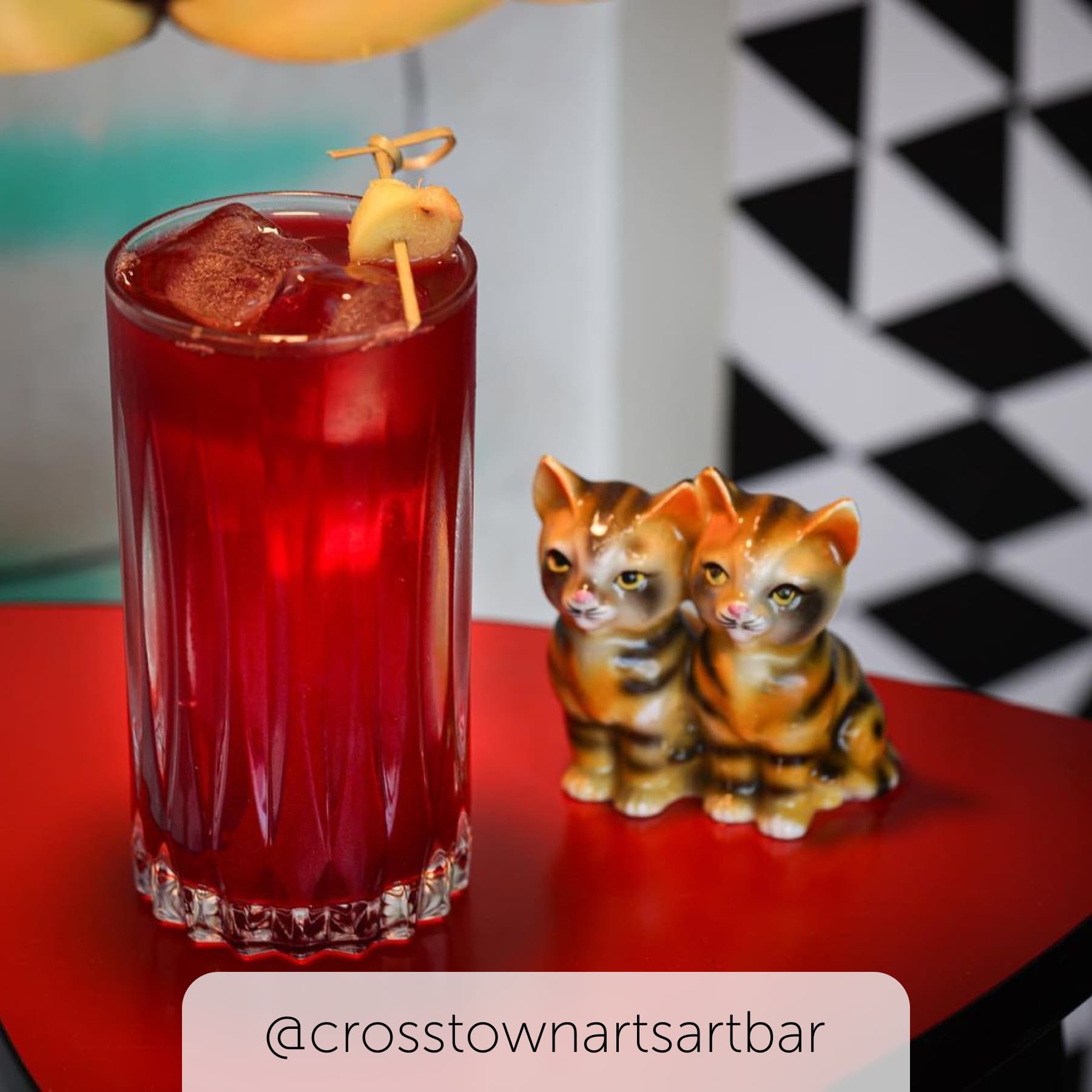 Small and intricate artistic cat ornaments sit next to a drink at the arts bar in Memphis