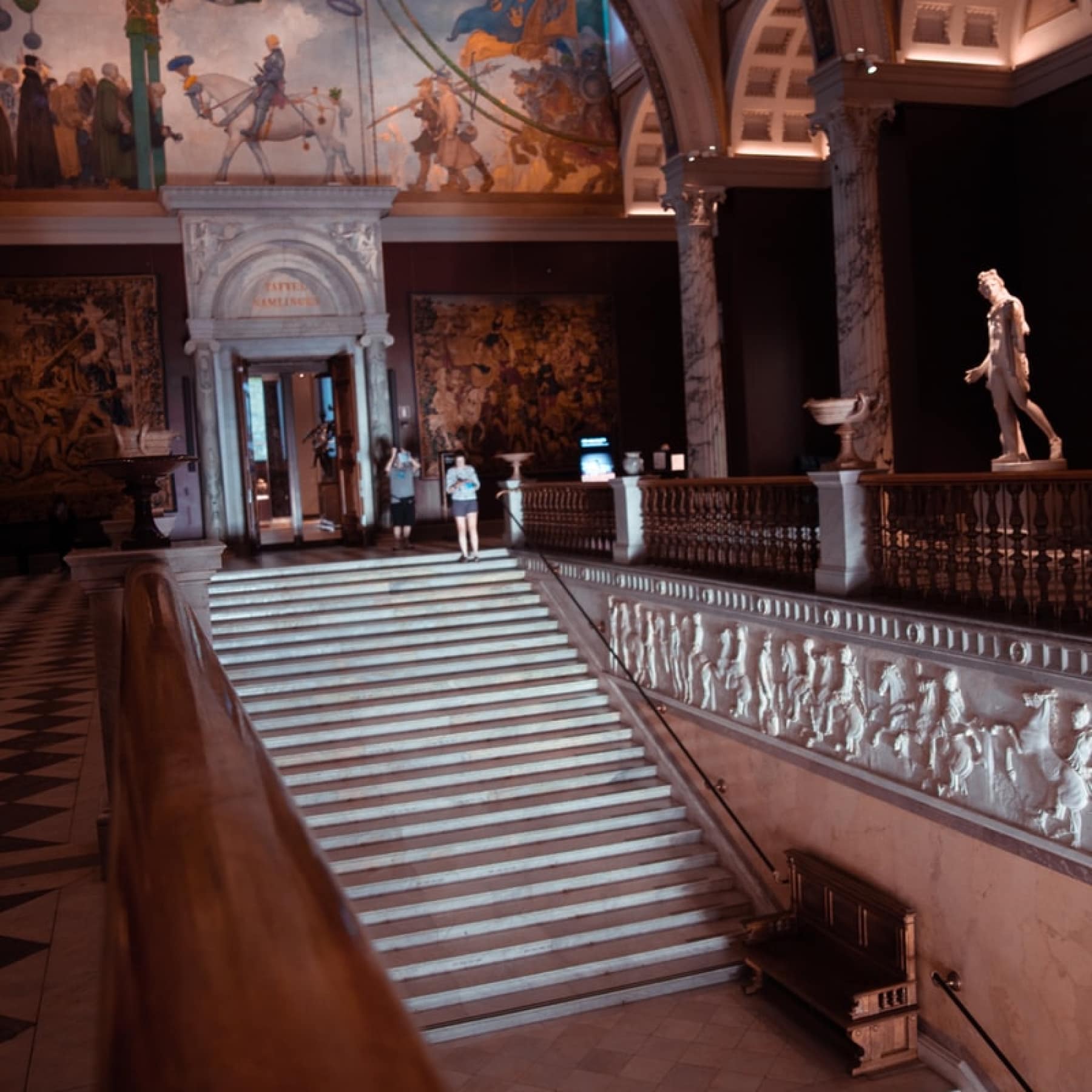 Large staircase in a museum in Stockholm with vast sculptures around it