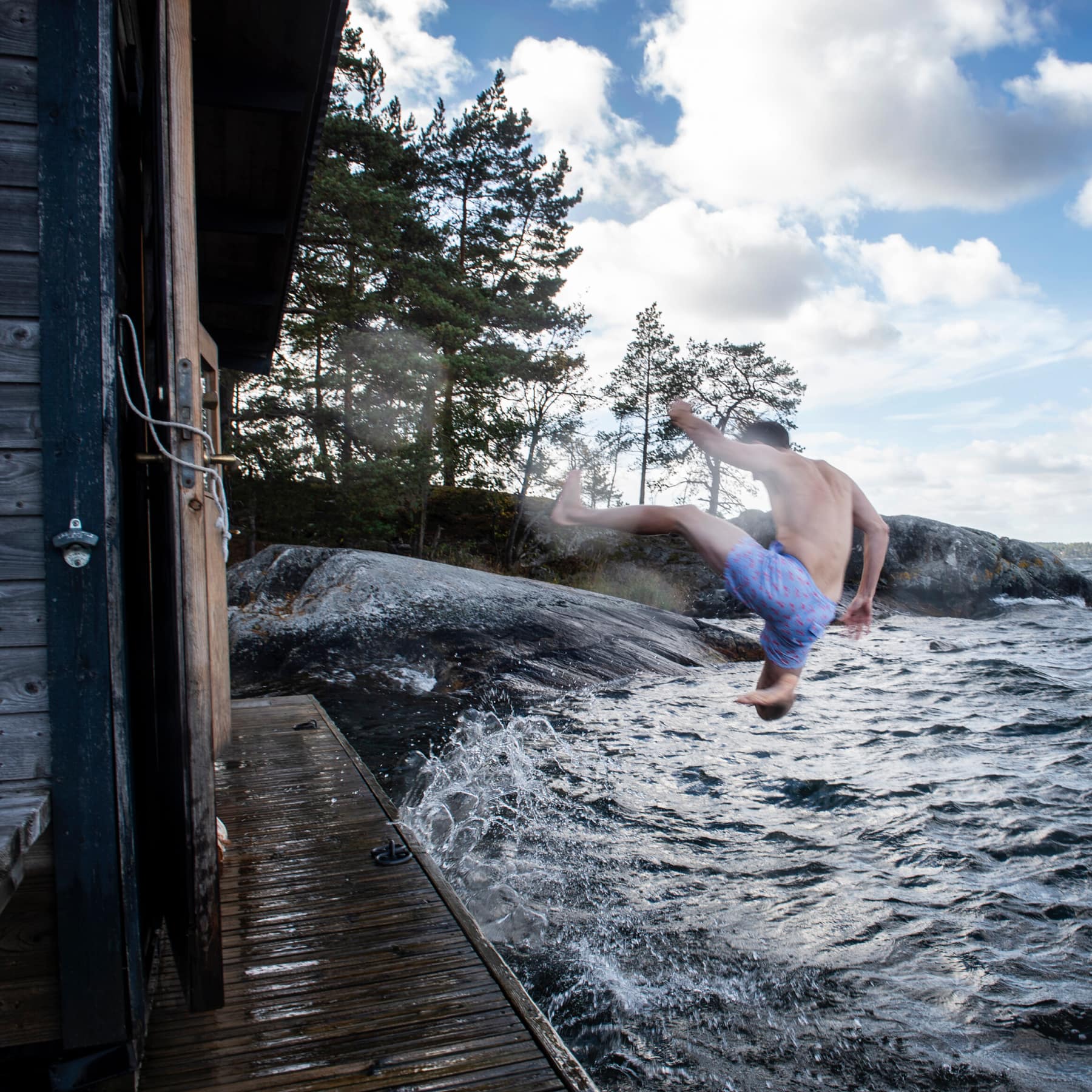 A sauna escape by a lake, with a man jumping into the water