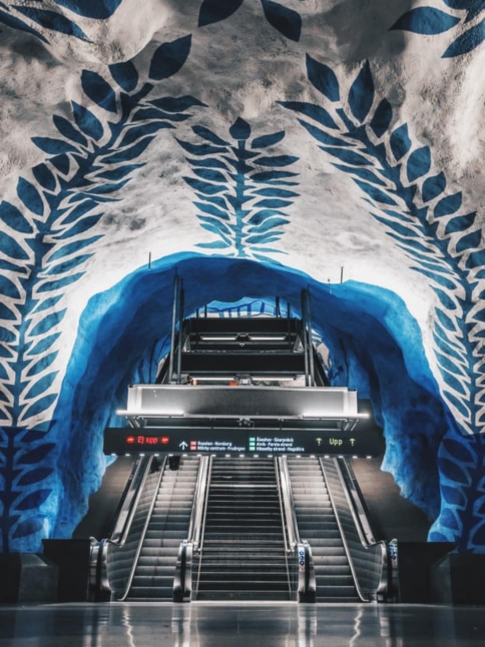 Elevators in a train station in Stockholm with incredible blue, floral mural on the ceiling