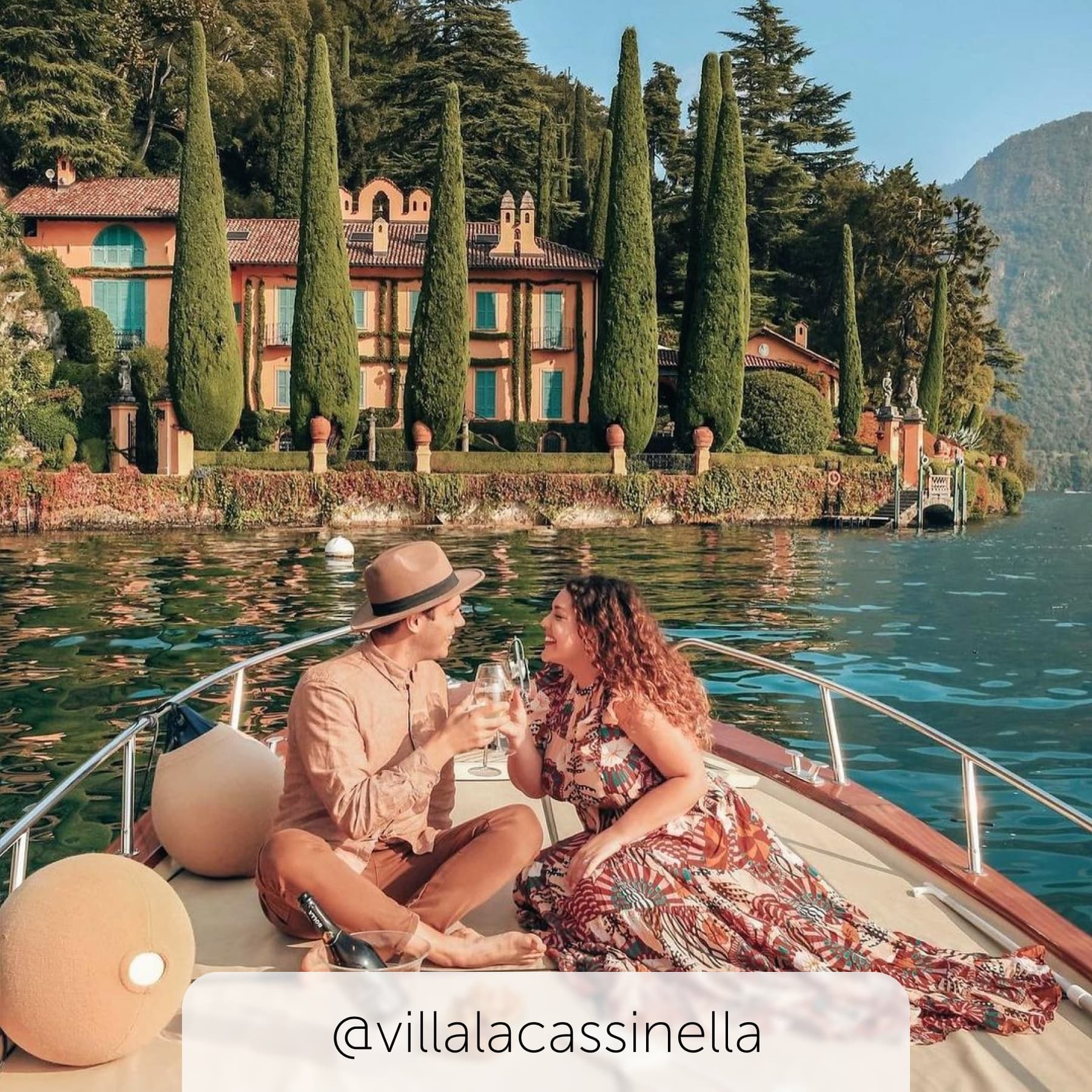 Couple sit on the water with Villa Cassinella sitting in the backdrop