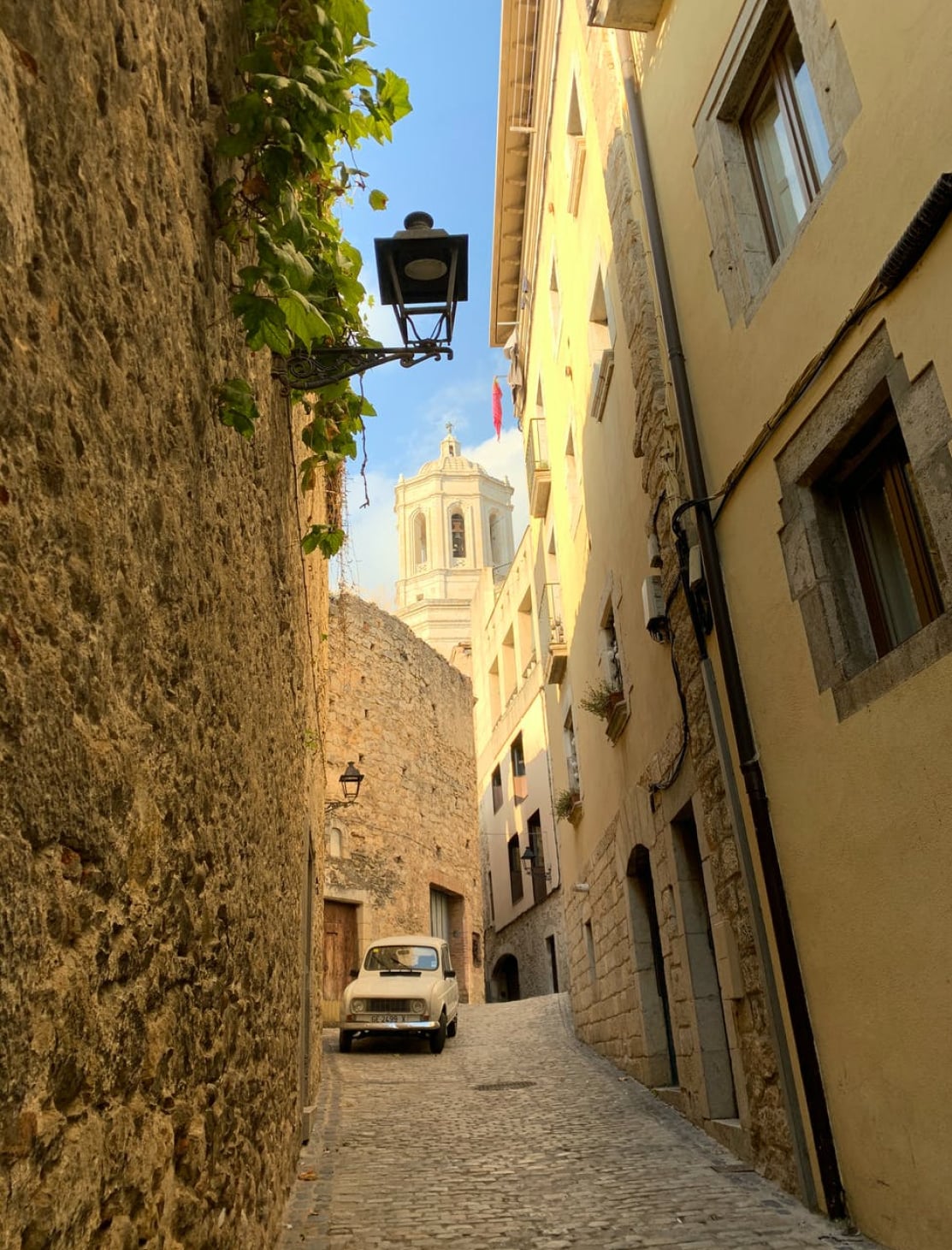 Sunkissed street in Girona with vintage car
