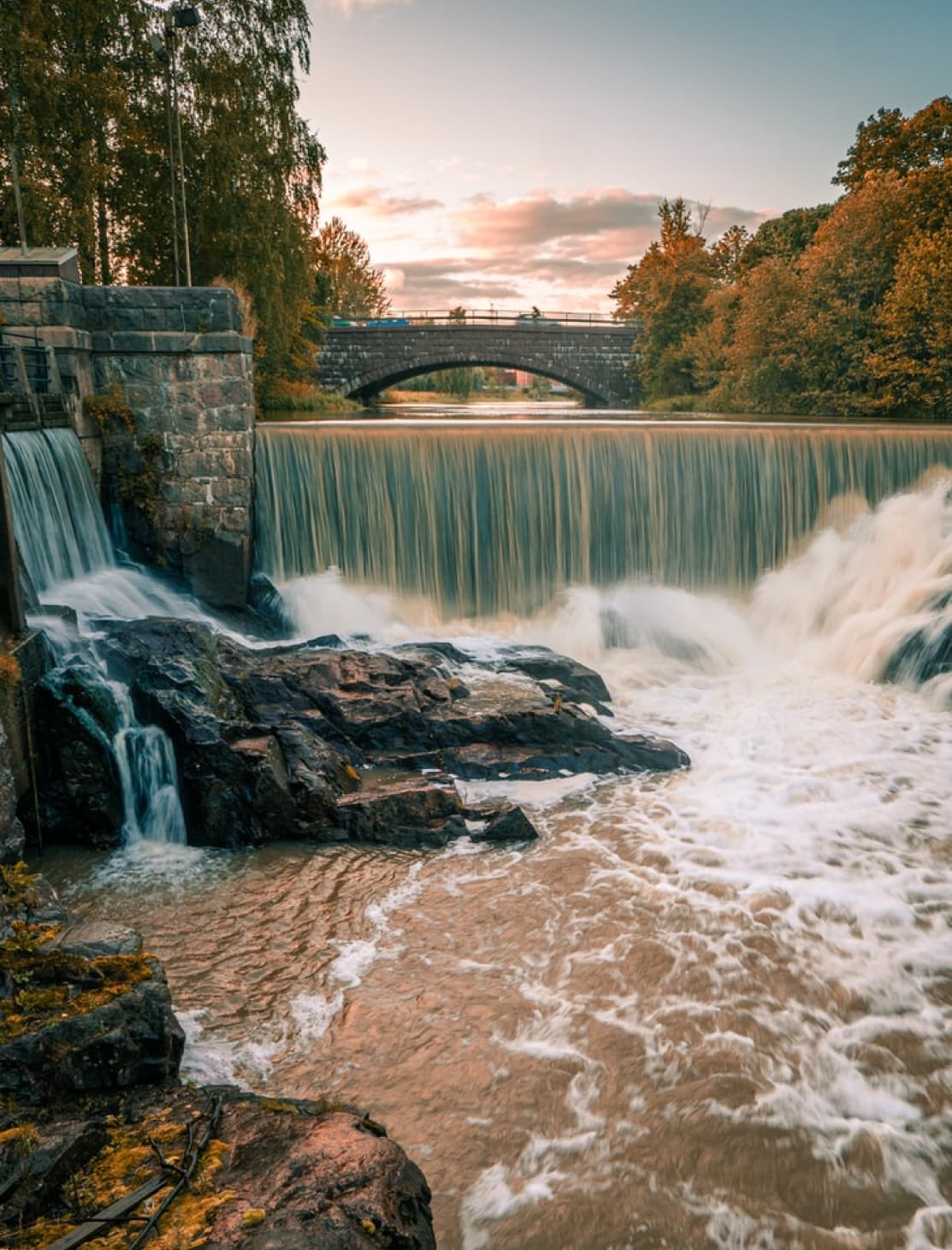 Waterfall with a bridge in the background in Helsinki