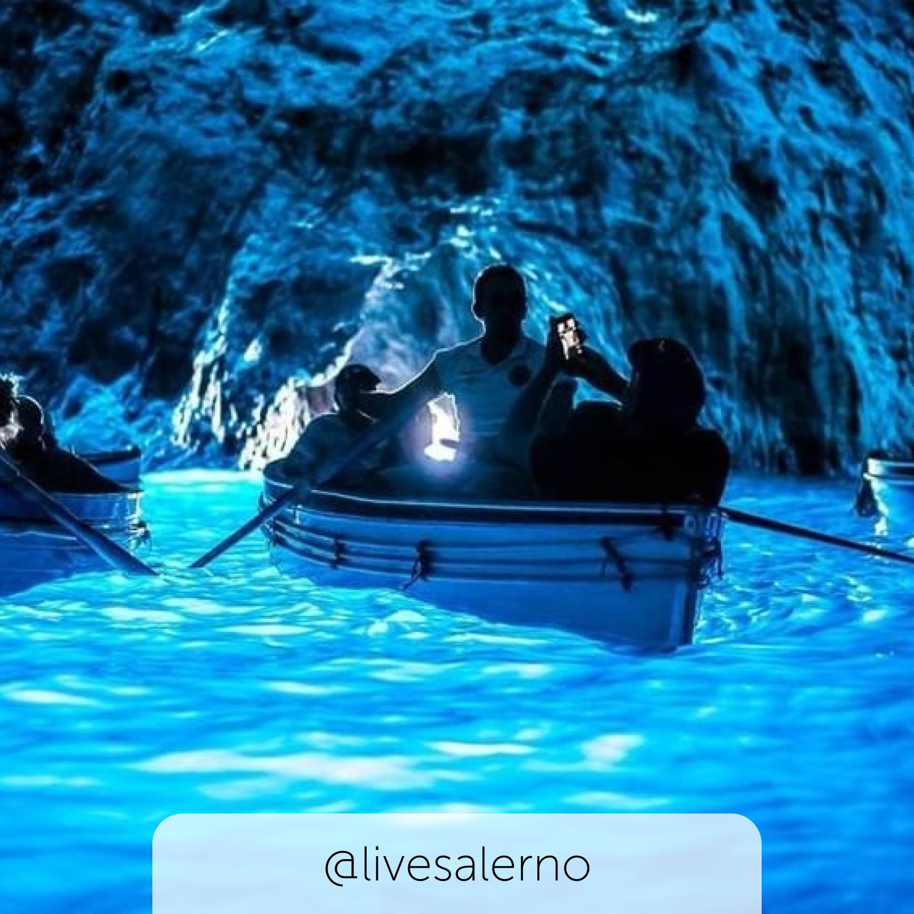 Stunning, glowing Blue Grotto with people on boat exploring